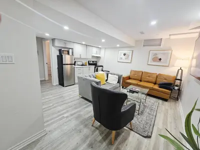 a living room with a couch and a table at Friendly Neighborhood Garden Ave Suite in Brantford