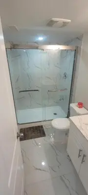 a bathroom with a glass shower and a toilet at Comfy basement near KW airport in Kitchener