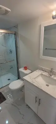 a bathroom with a toilet and a sink and a shower at Comfy basement near KW airport in Kitchener