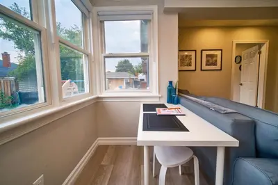a living room with a couch and a table and windows at Hamilton Oasis - Luxe Beds - BBQ Haven - Pool in Hamilton