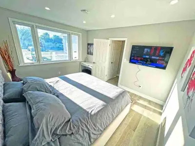 a bedroom with a bed and a flat screen tv at Hamilton Oasis - Luxe Beds - BBQ Haven - Pool in Hamilton
