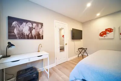 a bedroom with a bed and a desk and a tv at Hamilton Oasis - Luxe Beds - BBQ Haven - Pool in Hamilton