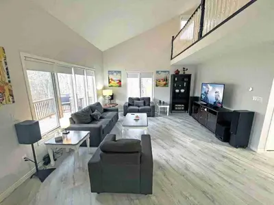 a living room with a couch and a tv at Forest Retreat - Pool - Games - Fireside Joy in Cayuga