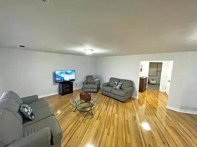 a living room with two couches and a flat screen tv at Forest Retreat - Pool - Games - Fireside Joy in Cayuga