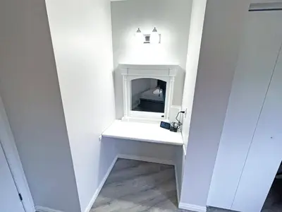 a white vanity in a room with a mirror at Forest Retreat - Pool - Games - Fireside Joy in Cayuga