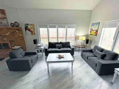 a living room with couches and a coffee table at Forest Retreat - Pool - Games - Fireside Joy in Cayuga