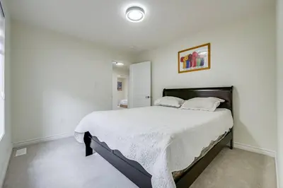 a bedroom with a large bed with white sheets at 922 Logan Drive in Milton