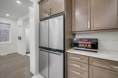 a kitchen with stainless steel refrigerator and wooden cabinets at 922 Logan Drive in Milton