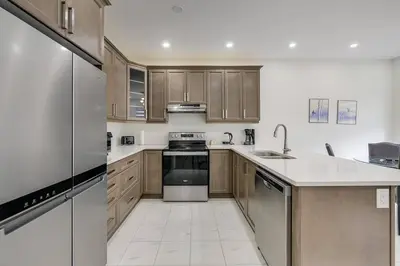 a kitchen with stainless steel appliances and wooden cabinets at 922 Logan Drive in Milton