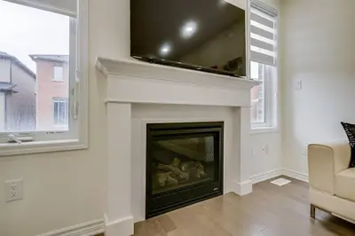 a living room with a fireplace with a tv above it at 922 Logan Drive in Milton