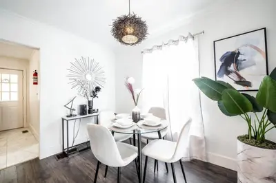 a dining room with a glass table and white chairs at Luxury Stylish Home, Walk to Falls, Fire Pit&More in Niagara Falls
