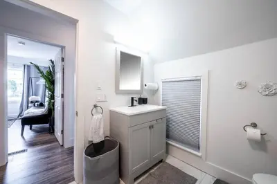 a white bathroom with a sink and a mirror at Luxury Stylish Home, Walk to Falls, Fire Pit&More in Niagara Falls