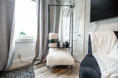 a living room with a chair and a window at Luxury Stylish Home, Walk to Falls, Fire Pit&More in Niagara Falls