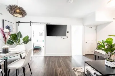 a living room with a table and a tv at Luxury Stylish Home, Walk to Falls, Fire Pit&More in Niagara Falls