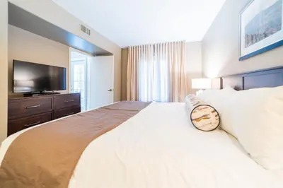 a bedroom with a large white bed with a flat screen tv at Horseshoe Valley Suites - The Aurora in Shanty Bay