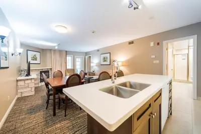 a kitchen with a sink and a dining room at Horseshoe Valley Suites - The Aurora in Shanty Bay