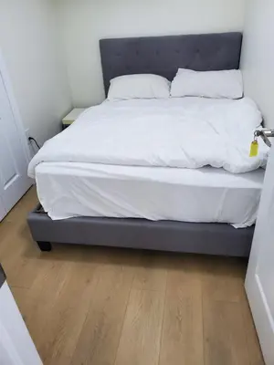 a bed with white sheets and pillows in a bedroom at RAESABU GUEST HOUSE in Brampton