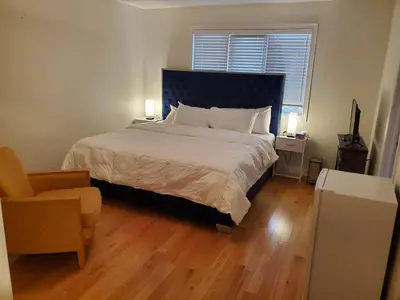 a bedroom with a bed and a chair and a window at RAESABU GUEST HOUSE in Brampton
