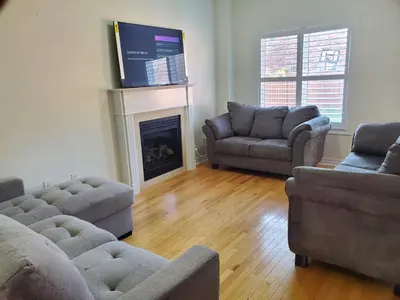a living room with three couches and a fireplace at RAESABU GUEST HOUSE in Brampton