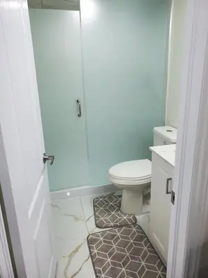 a white bathroom with a toilet and a shower at RAESABU GUEST HOUSE in Brampton