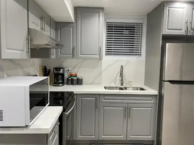 a white kitchen with white cabinets and a sink at Spacious 5BR Home for Families & Business Travelers in Ajax