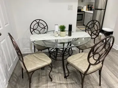 a dining room table with four chairs and a white table at Spacious 5BR Home for Families & Business Travelers in Ajax