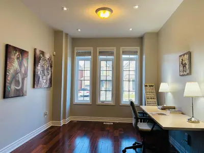 an empty office with a desk and two windows at Spacious 5BR Home for Families & Business Travelers in Ajax