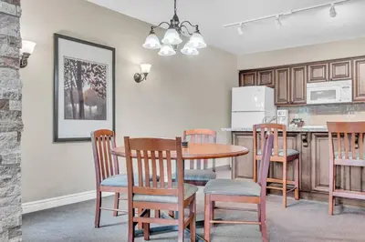 a kitchen with a table and chairs and a kitchen with a refrigerator at Spacious Hideaway in Nature in Edgar