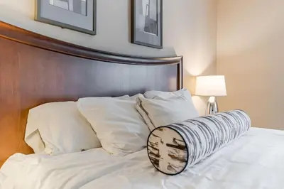 a bed with a wooden head board and white pillows at Cozy Getaway with Resort Perks in Edgar