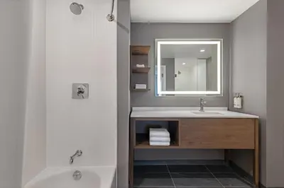 a bathroom with a sink and a mirror and a tub at Staybridge Suites Port Elgin by IHG in Port Elgin