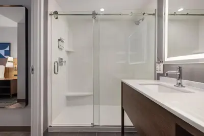 a bathroom with a glass shower with a sink at Staybridge Suites Port Elgin by IHG in Port Elgin