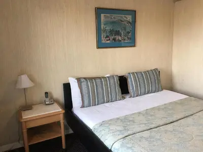 a hotel room with two beds and a table with a phone at Mayflower Motel in Kitchener