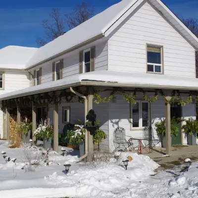 a white house with snow on the ground at Fells Meadows Farmhouse on Country Property in Castleton