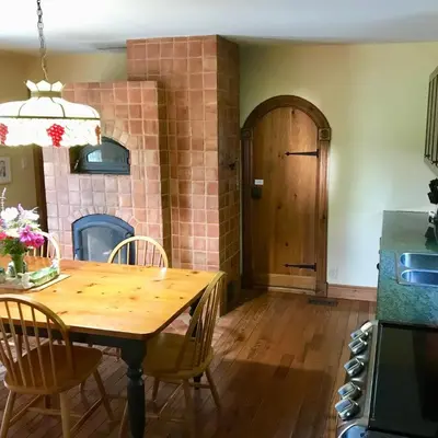 a kitchen with a wooden table with chairs and a door at Fells Meadows Farmhouse on Country Property in Castleton