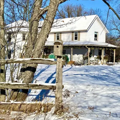 a wooden fence in front of a house in the snow at Fells Meadows Farmhouse on Country Property in Castleton