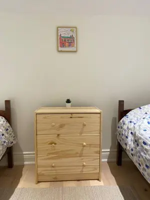 a wooden dresser in a bedroom with two beds at Downtown Picton 3 bedroom in Picton