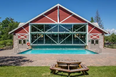 a building with a pool and a picnic table in front of it at Country Club Charm - 4-Bed Radiant Resort Condo in Edgar