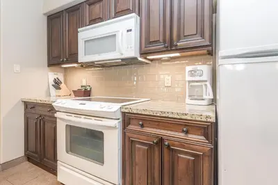 a kitchen with wooden cabinets and white appliances at Country Club Charm - 4-Bed Radiant Resort Condo in Edgar