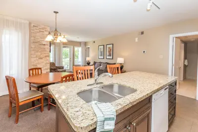 a kitchen and living room with a sink and a table at Country Club Charm - 4-Bed Radiant Resort Condo in Edgar