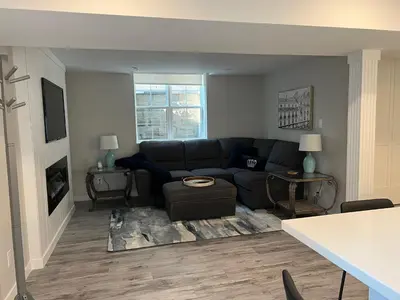 a living room with a black couch and two tables at The Croft House - 2 Bedroom 1 Bathroom Suite in Burlington
