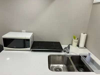a kitchen counter with a microwave and a sink at Cozy 1.5 Guest-Suite in Aurora
