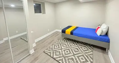 a small bedroom with a bed and a mirror at Cozy 1.5 Guest-Suite in Aurora