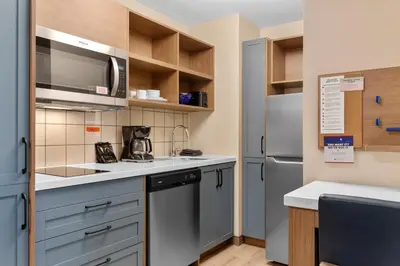 a kitchen with a sink and a refrigerator at Candlewood Suites Collingwood by IHG in Collingwood