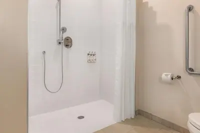 a bathroom with a shower with a glass door at Candlewood Suites Collingwood by IHG in Collingwood