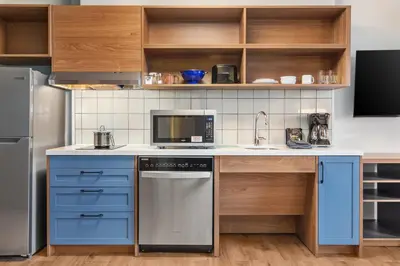 a kitchen with blue cabinets and a dishwasher at Candlewood Suites Collingwood by IHG in Collingwood