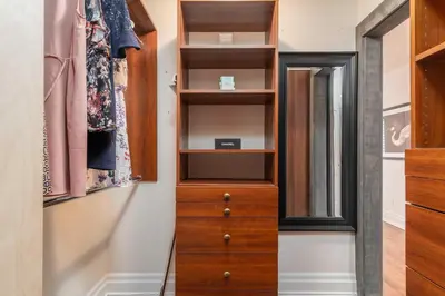 a closet with a wooden dresser and a mirror at Beautiful 3BR House in the Heart of Greek Town in Toronto