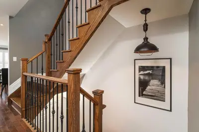 a staircase with a picture and a pendant light at Beautiful 3BR House in the Heart of Greek Town in Toronto