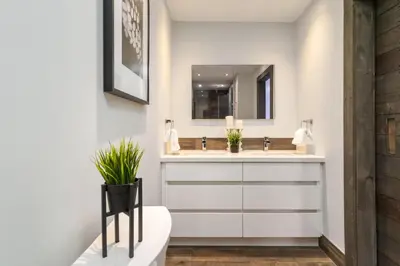 a bathroom with a sink and a toilet and a mirror at Beautiful 3BR House in the Heart of Greek Town in Toronto