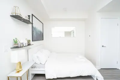 a white bedroom with a bed and a desk at Beautiful Luxurious Modern Condo With Breathtaking Views in Toronto