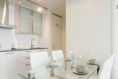 a kitchen with a glass table and white cabinets at Beautiful Luxurious Modern Condo With Breathtaking Views in Toronto